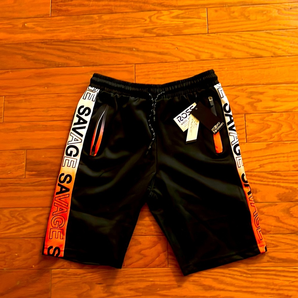 Black and orange boys shorts that says Savage on the side of them.